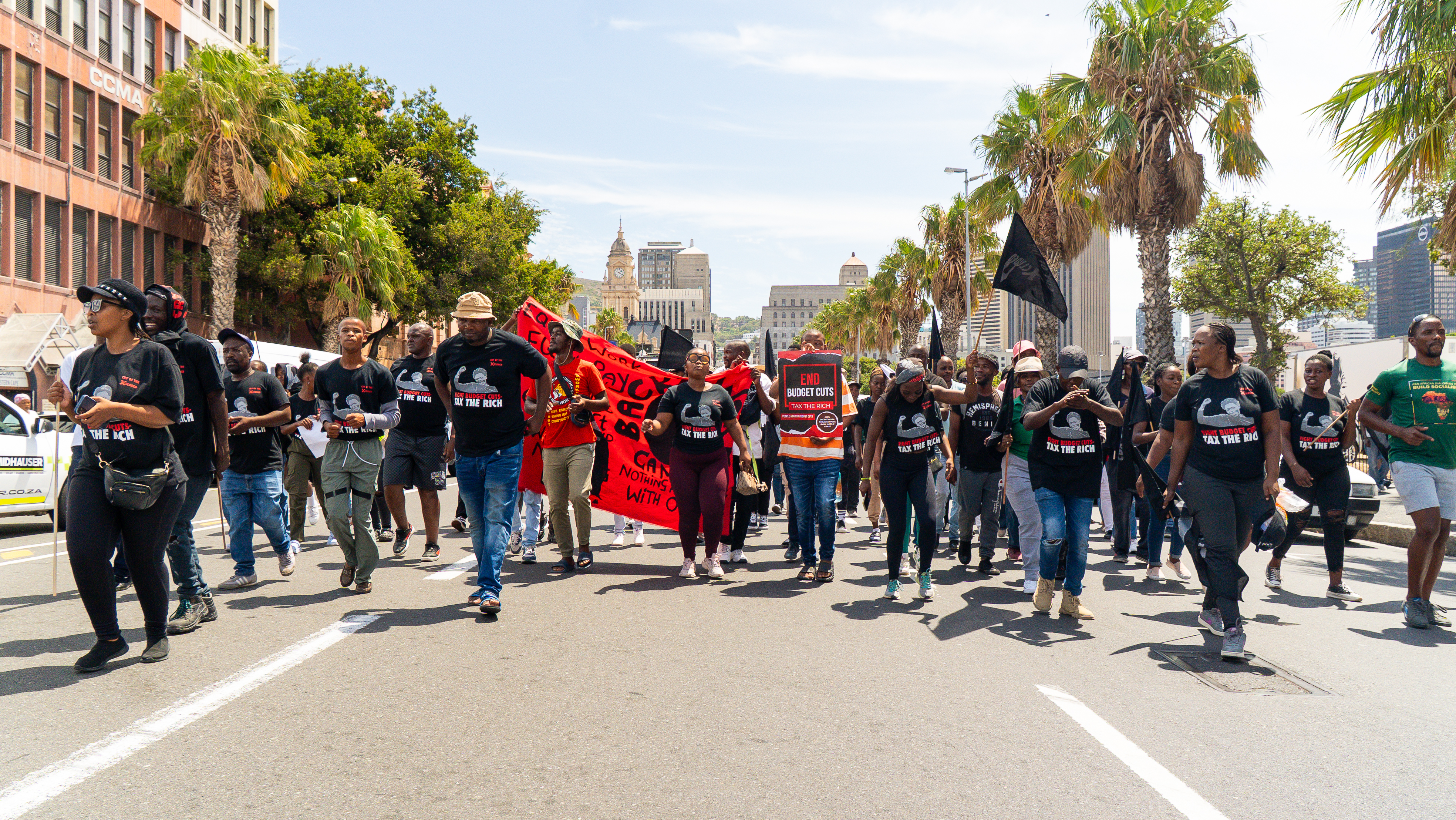 Community members marching through Cape Town streets with banners and placards